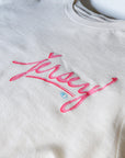 Natural t-shirt with pink Jersey script graphic laid flat