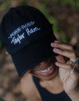 Woman wearing black baseball cap with Taylor Ham embroidery