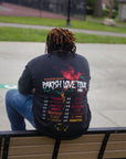 man sitting on park bench wearing black parish love tour t-shirt outdoors casual streetwear