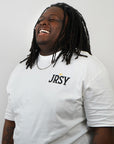 man in white contant avenue JRSY t-shirt