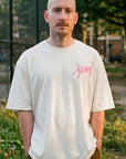 Man wearing natural Jersey script t-shirt standing outdoors