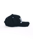 Angled side view of black baseball cap with distressed finish