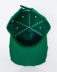 Interior view of green cap showing satin lining and inner construction