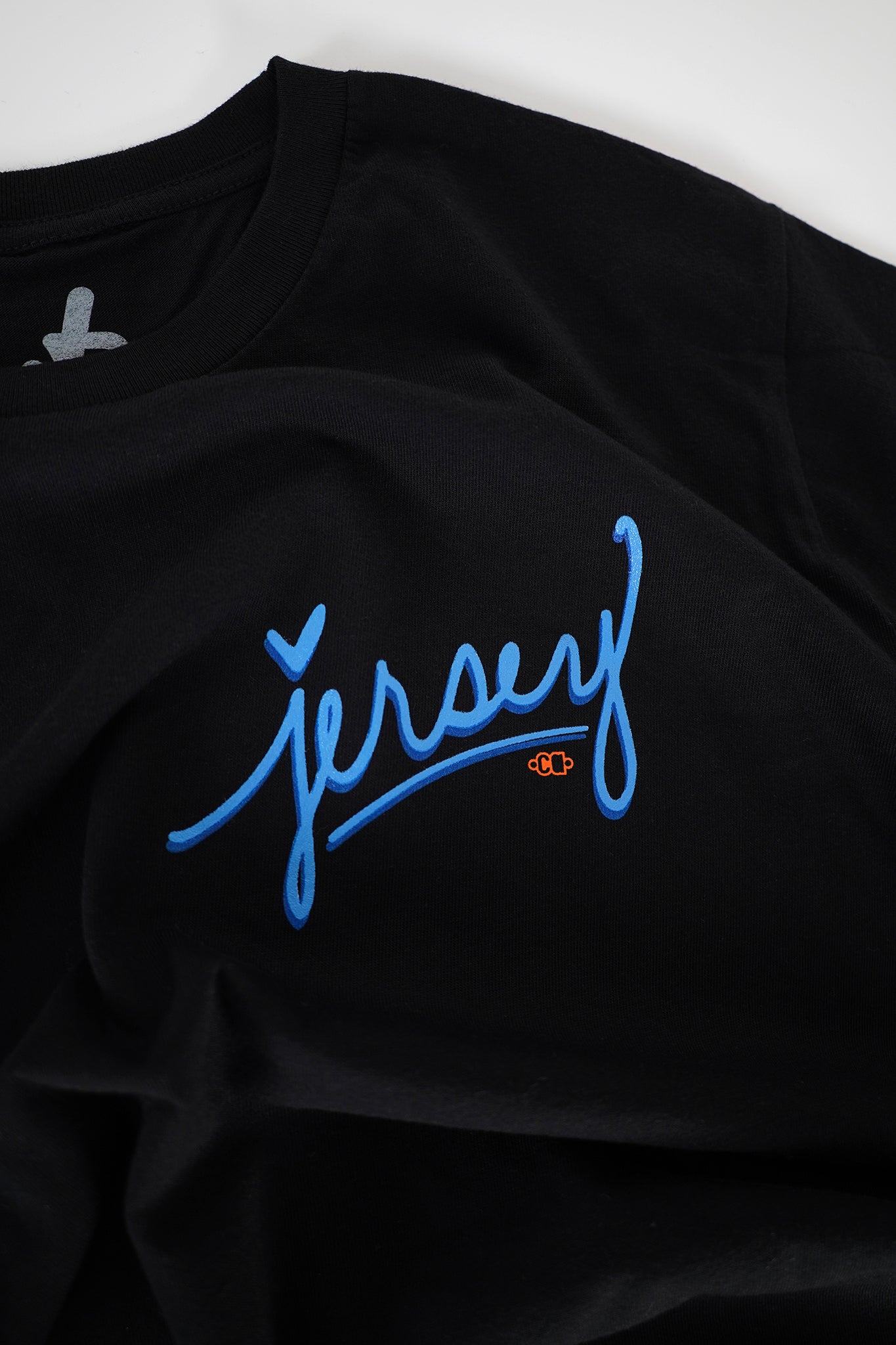 Close-up detail of the electric blue screenprint on the Blue Jersey Love Tee in Black by Wakefield District's Contant Avenue collection. Premium heavyweight cotton texture.