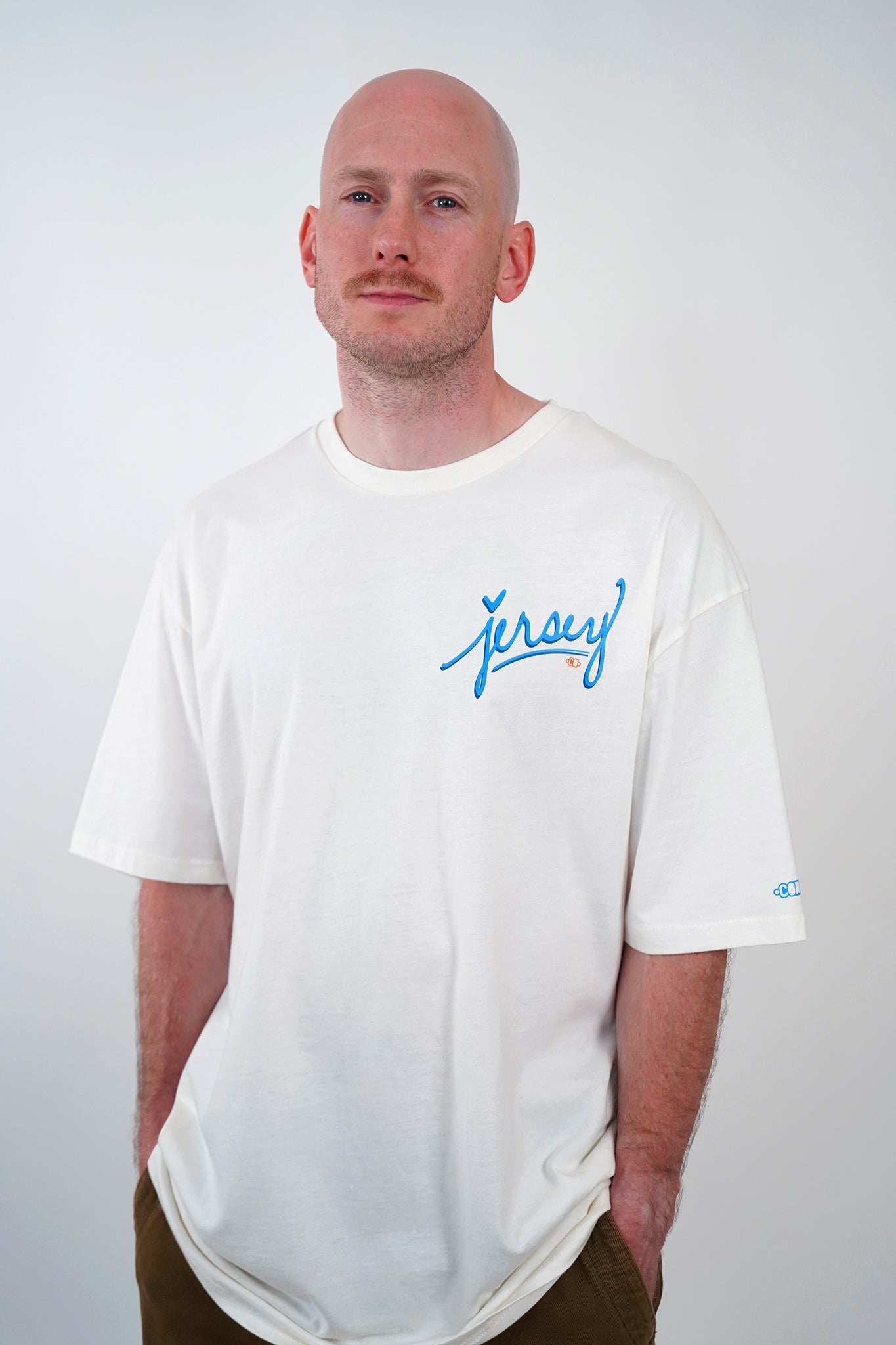 Man wearing Blue Jersey Love Tee in Natural by Wakefield District. Premium streetwear fit with blue graphic text.
