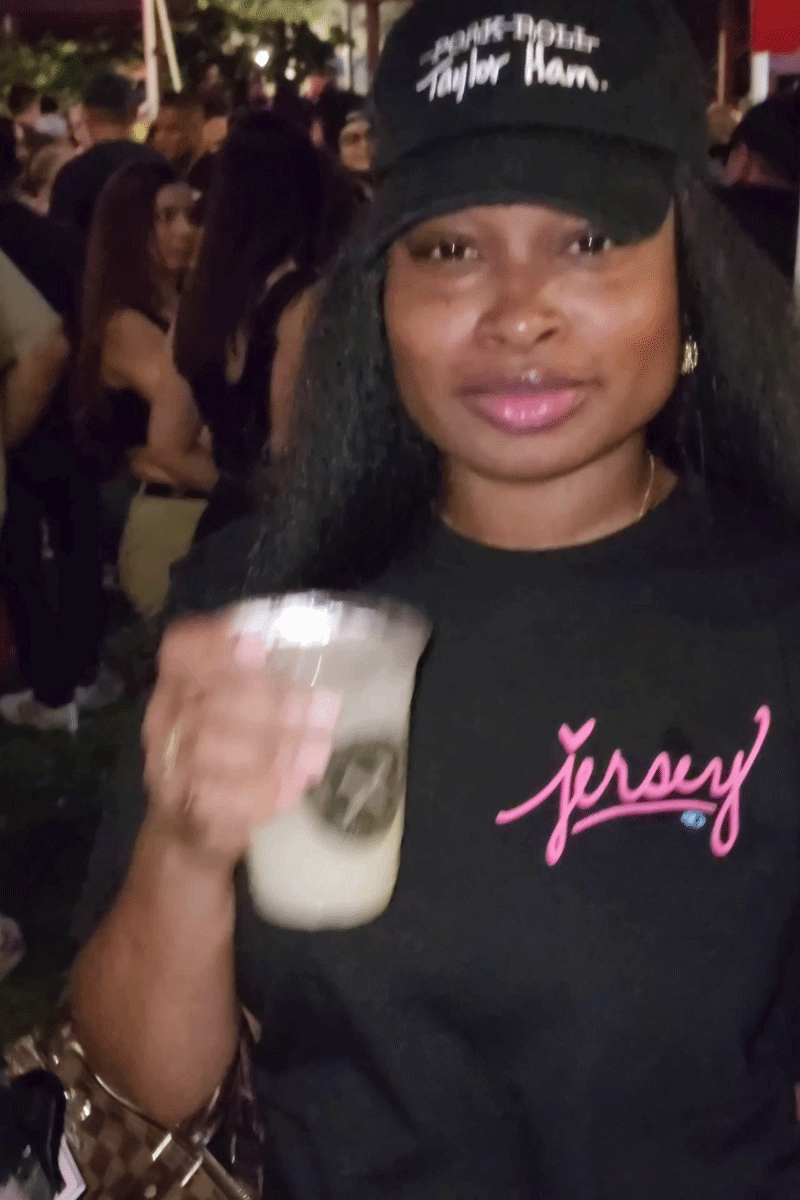Woman wearing the Wakefield District Pink Jersey Love Tee in Black. Urban streetwear lifestyle fit showing bold pink graphic.