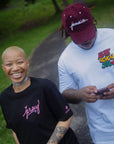 woman wearing black jersey script t-shirt with pink logo outdoors on park path casual streetwear