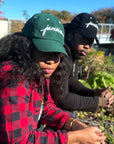 man and woman wearing Wakefield District Jamaica Signature Cord Hat in black and Jasper green