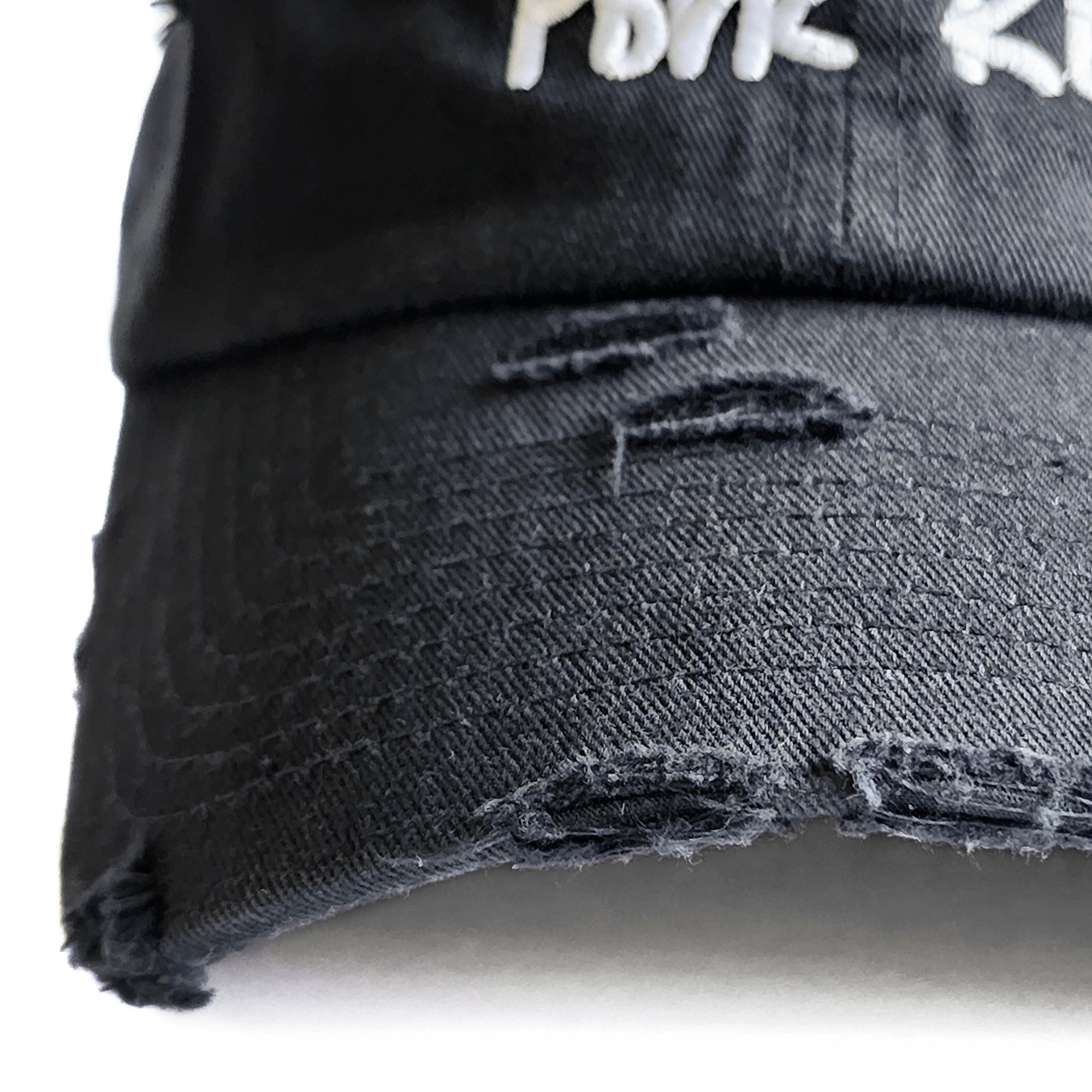 Close-up detail of the vintage distressed brim on the Black Signature Pork Roll Hat by Wakefield District, part of the Contant Avenue collection.