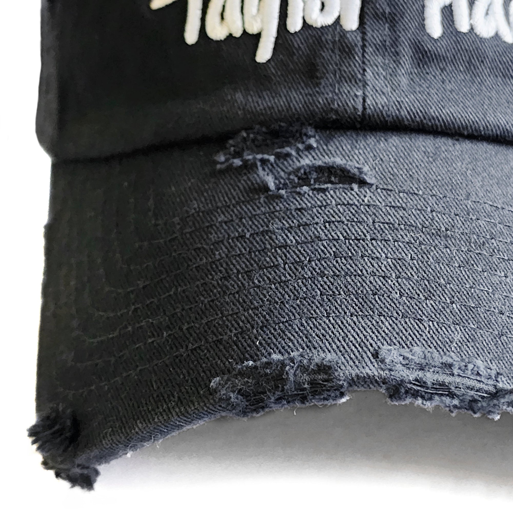 Close-up detail of the vintage distressed brim and thick white embroidery on the Black Signature Taylor Ham Hat by Wakefield District, part of the Contant Avenue collection.